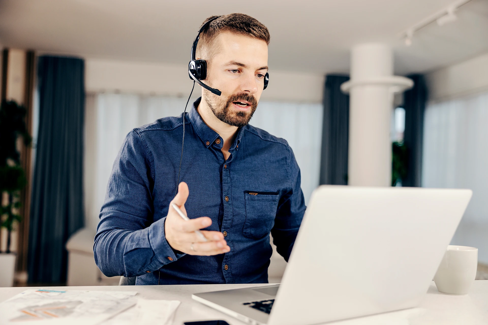 Guy sitting in front of a Laptop making a Translation from Home.